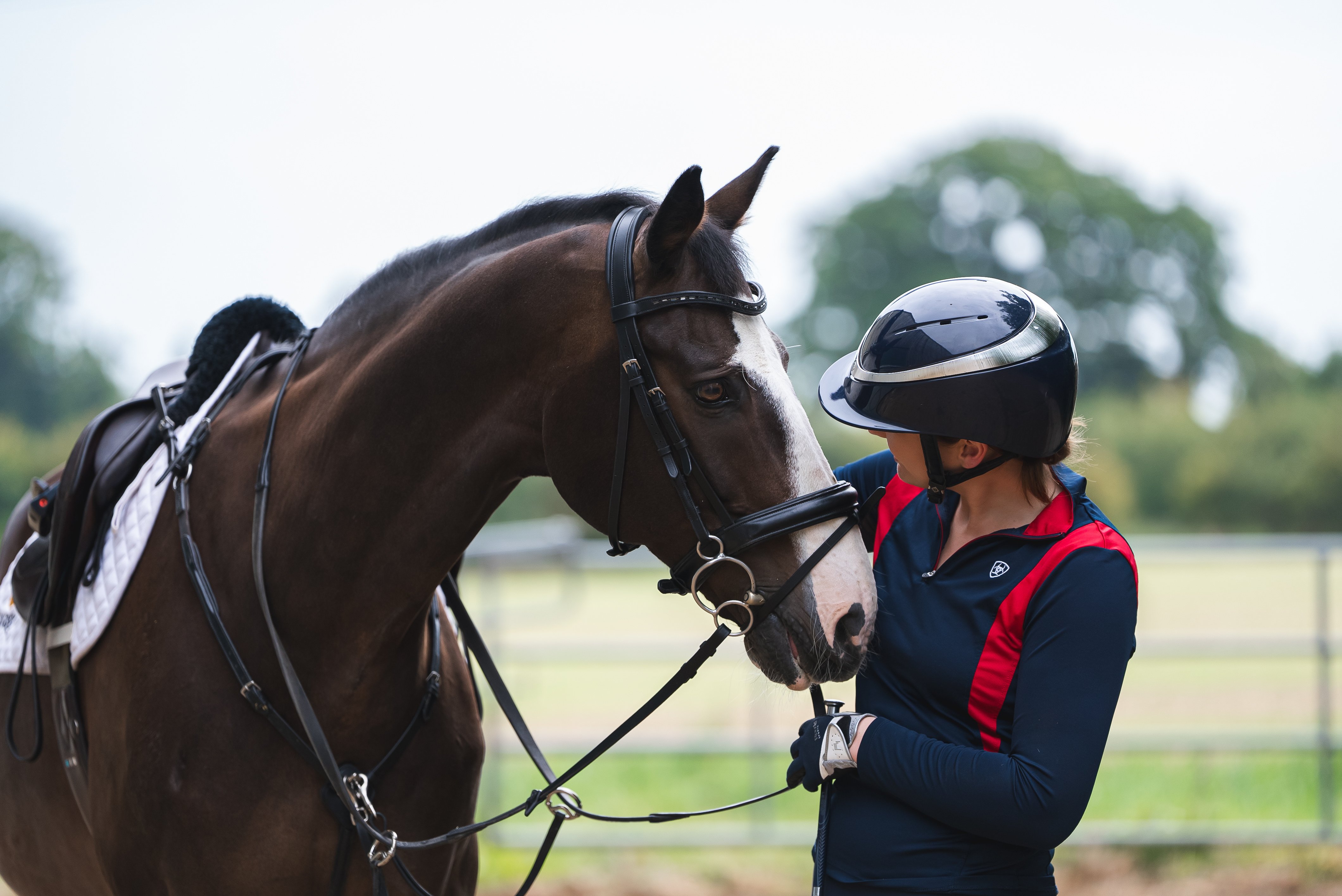 Woman next to horse wearing a Charles Owen riding helmet.