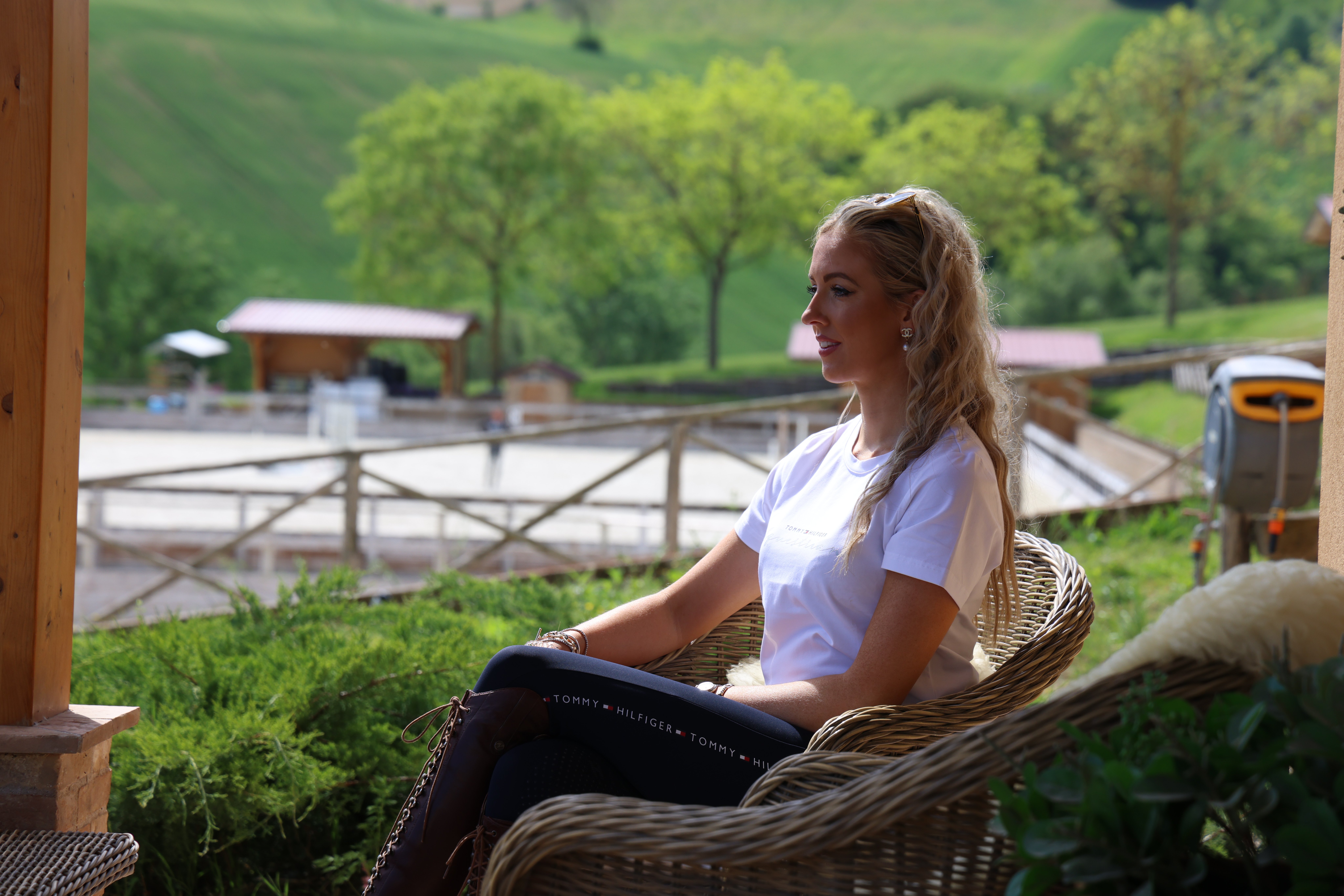 Woman wearing long riding boots sat in Italy.